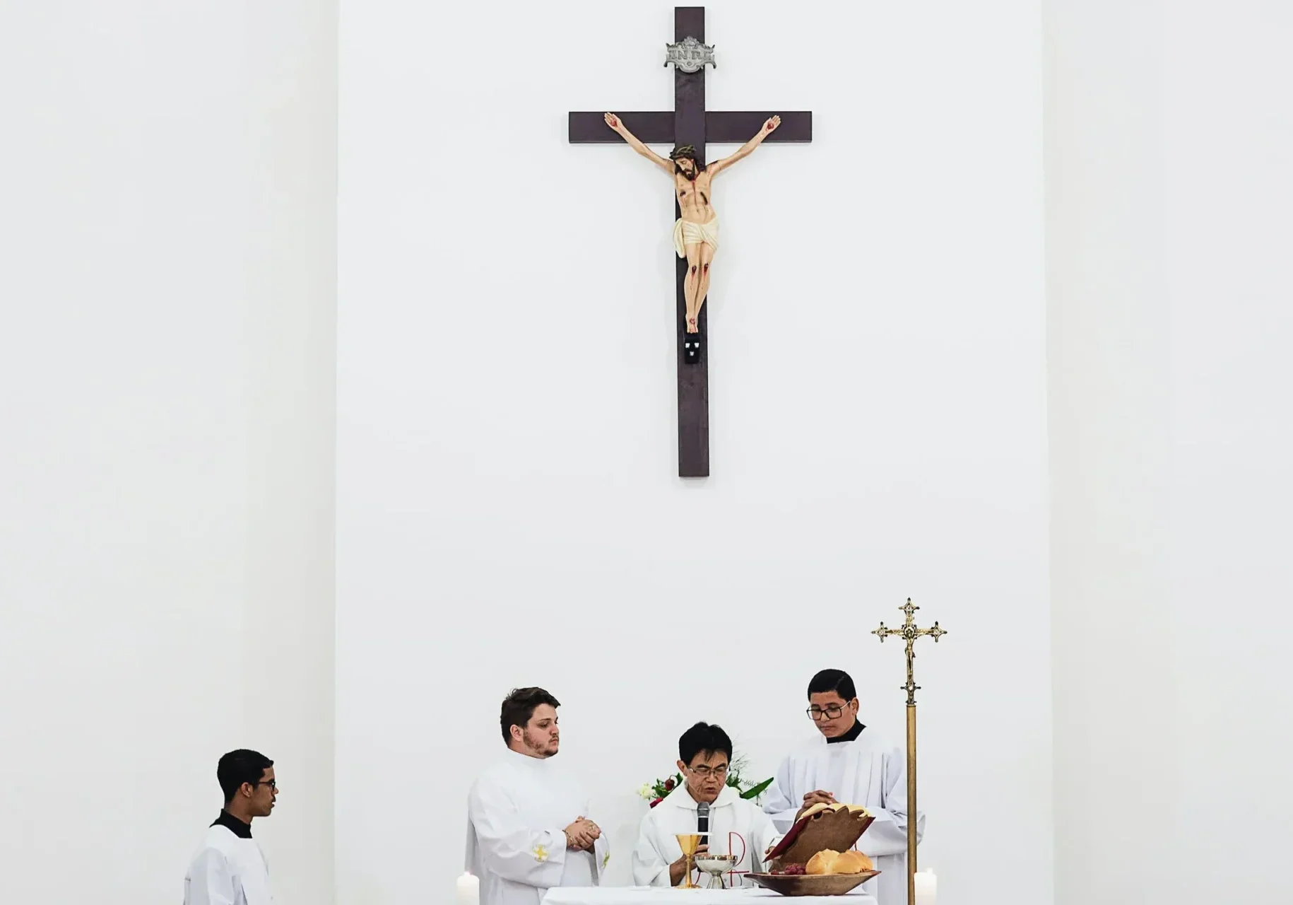 four people praying in a church in white attire